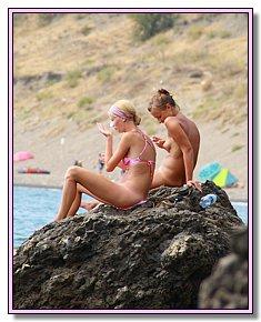 Weak on the front end cute nudists warms naked vagina in the sun on a hot sand