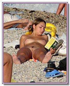 horny female nude chicks warms naked vagina in the sun under hot sun at beach