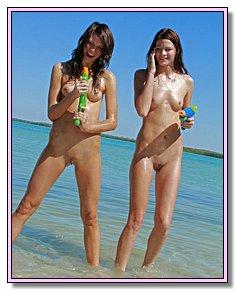 obscene teeny girls warms naked vagina in the sun on the beach near the sea