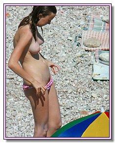 bashful female naturists sunbathes in the beach of nudists